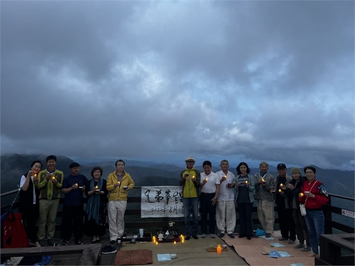 어둠이 내리는 가운데 차인들이 서서 촛불을 들고 기념사진을 찍고 있다. 사진=나광호
