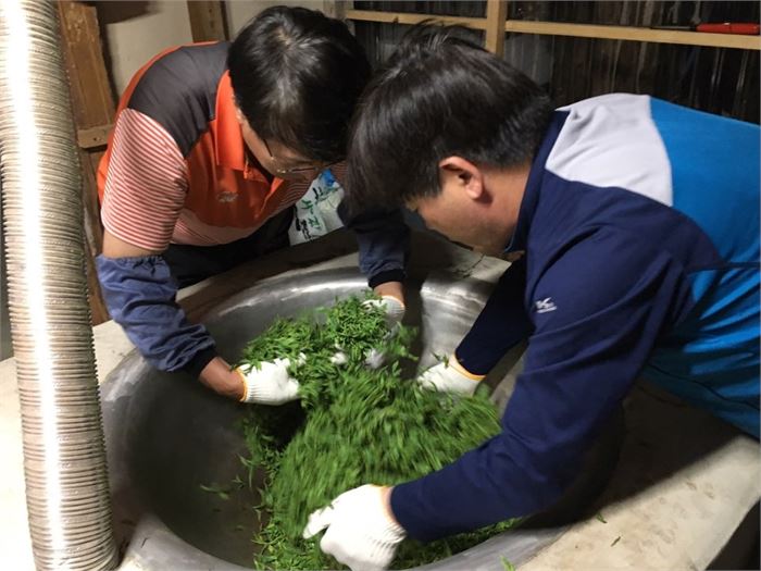 황근희 시인(오른쪽)과 정성기 시인이 차솥에서 찻잎을 덖고 있다.
