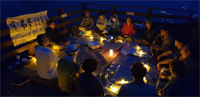 어둠 속에서 형제봉 활공장 데크에 앉아 차인들이 차회를 하고 있다. 사진=나광호